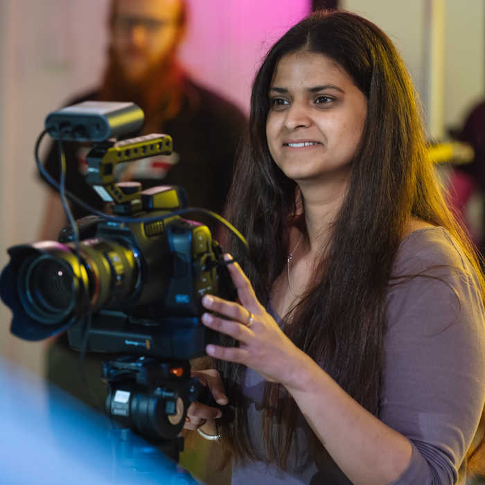 Female student filming with a camera