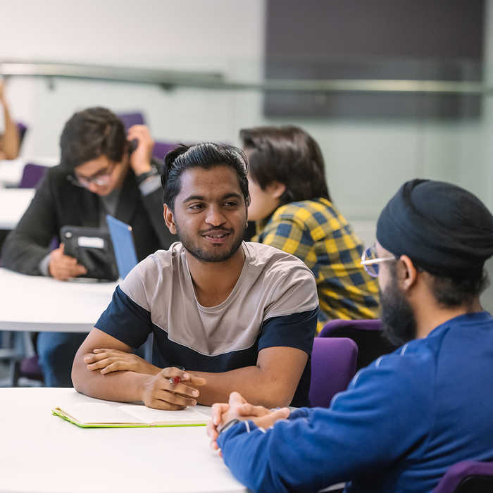 Social work students talking at their desk