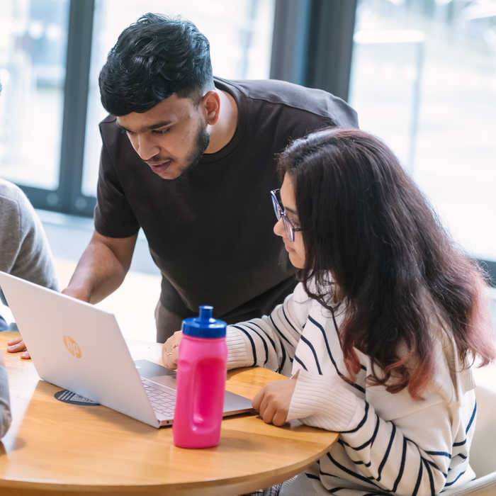 Male and female student looking at the laptop