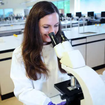 image of student looking into science machine