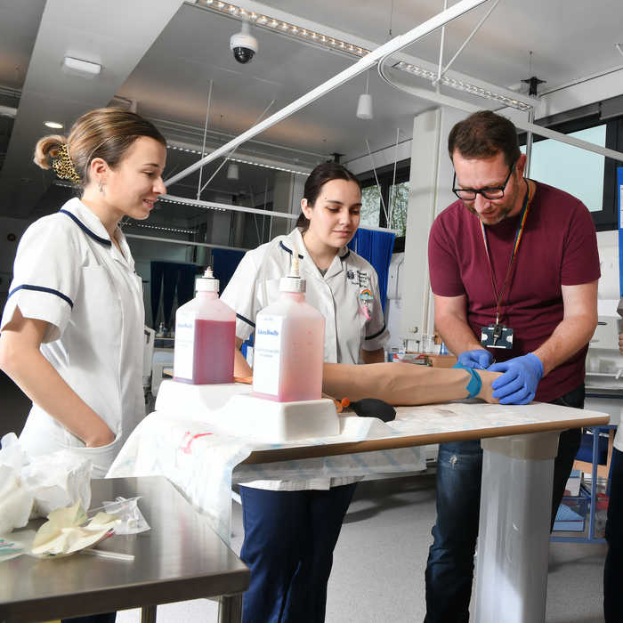Nursing students watching lecturer in practical session