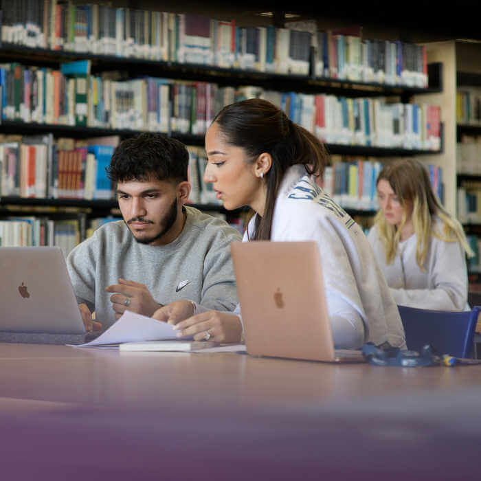 Students studying with laptops in library
